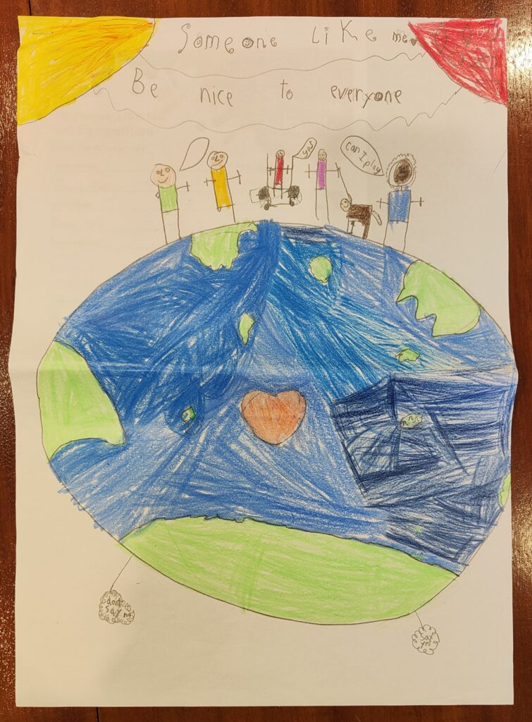A piece of paper with a child's drawing of a planet earth and people