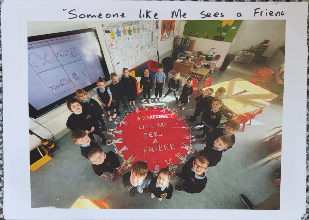 A group of children standing in a circle in a classroom with a sign in the middle