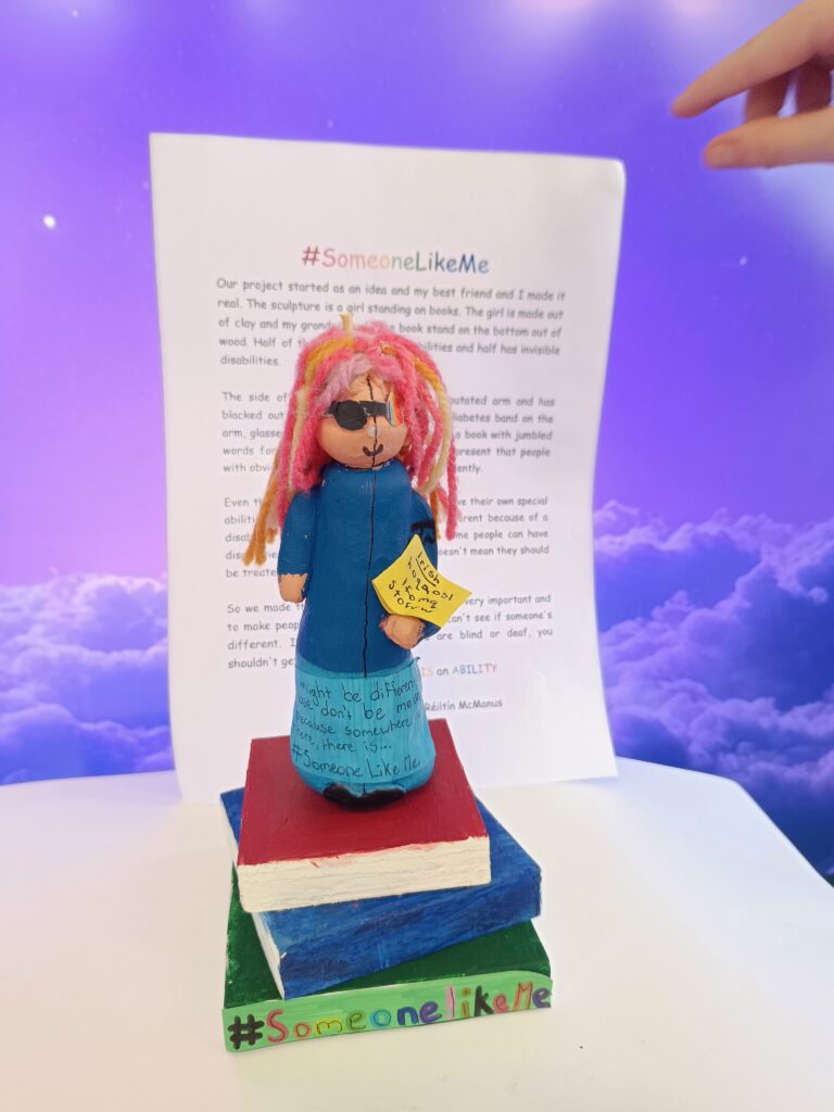 Paper sculpture of a blind person standing on a stack of books, symbolizing knowledge, strength, and overcoming challenges.