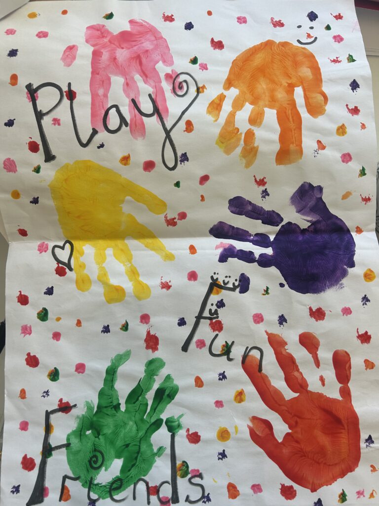 Finger-painted artwork with vibrant, colorful patterns and the caption 'Play' written boldly, emphasizing creativity and fun.