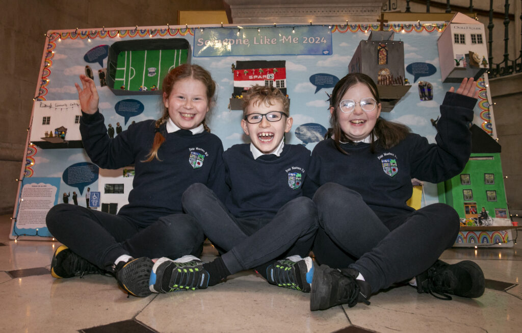 Children sitting in front of their artwork