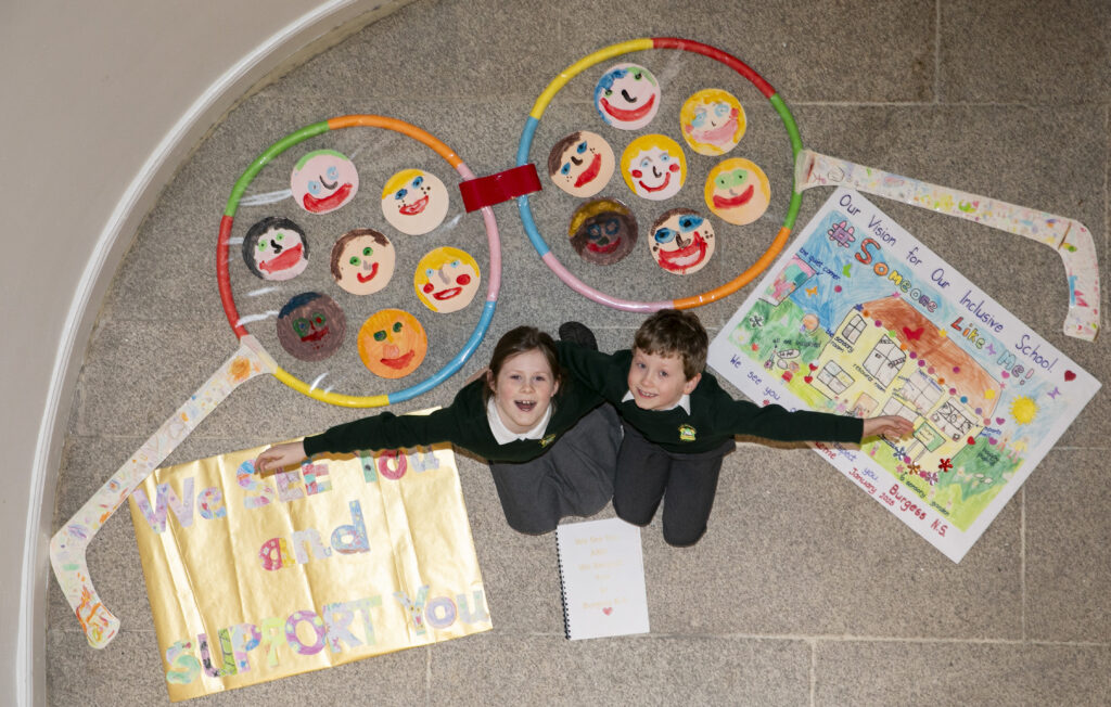 Children posing with their artwork glasses